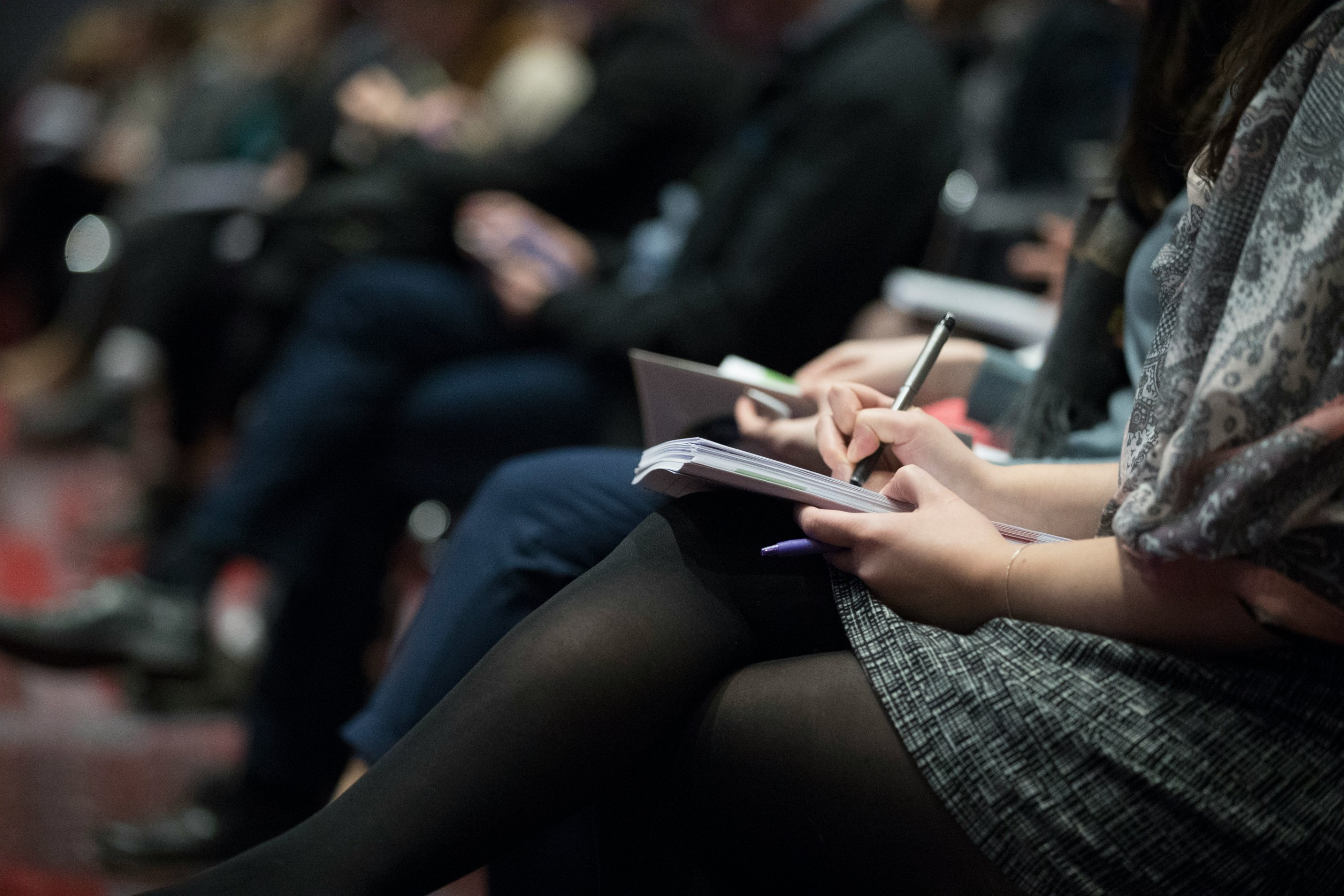 Participante prenant des notes lors d'une conférence