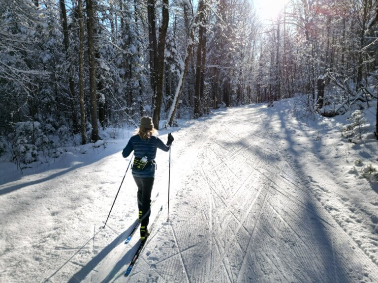 Skieuse de fond sur un sentier enneigé au Mont-Sainte-Anne