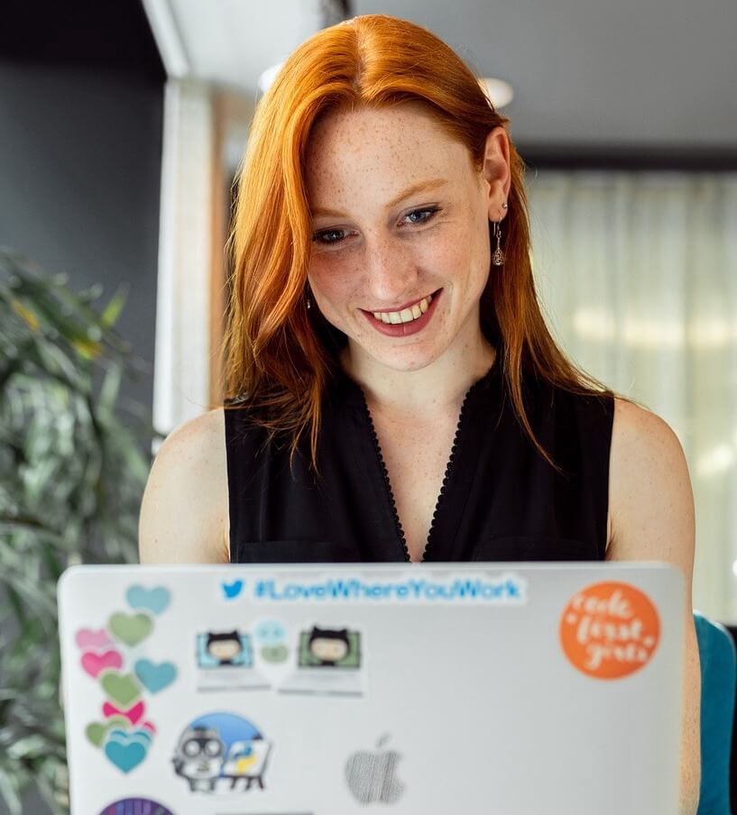 Femme souriante consultant le portail RHinno à l'ordinateur portable